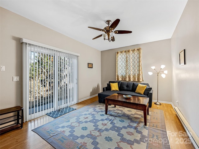 living room featuring wood-type flooring, ceiling fan, and baseboard heating