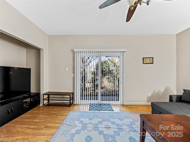 living room with ceiling fan and wood-type flooring