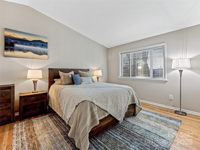 bedroom featuring lofted ceiling and hardwood / wood-style floors