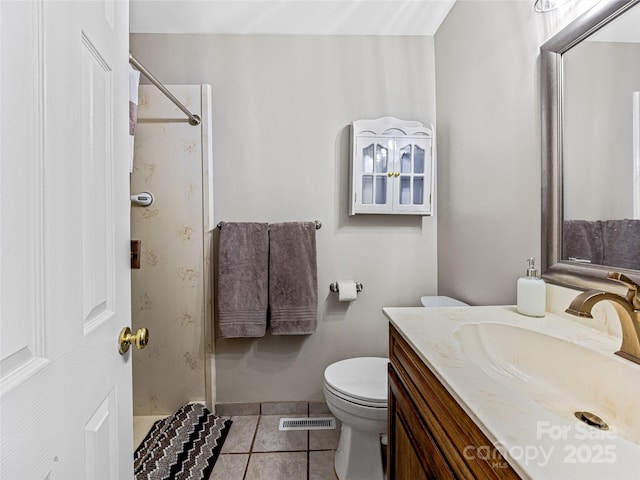 bathroom featuring tile patterned flooring, a shower, vanity, and toilet