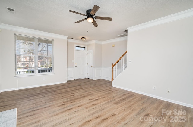 interior space featuring light wood finished floors, visible vents, stairs, crown molding, and a textured ceiling