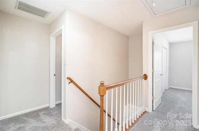 corridor featuring light colored carpet, baseboards, visible vents, and an upstairs landing