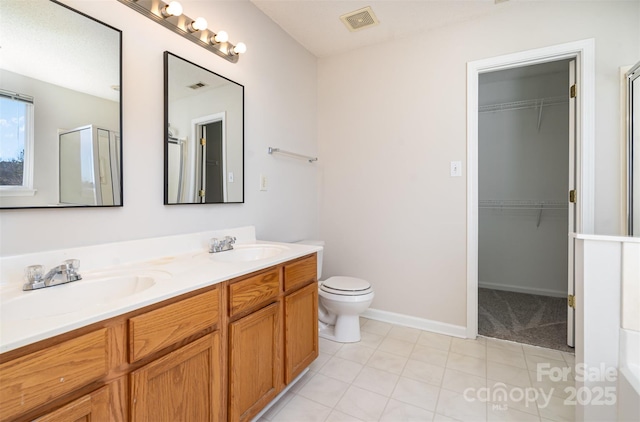 full bath with visible vents, a sink, a shower stall, and double vanity