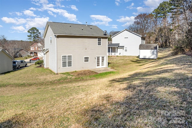 back of property featuring a shed, a lawn, and an outdoor structure