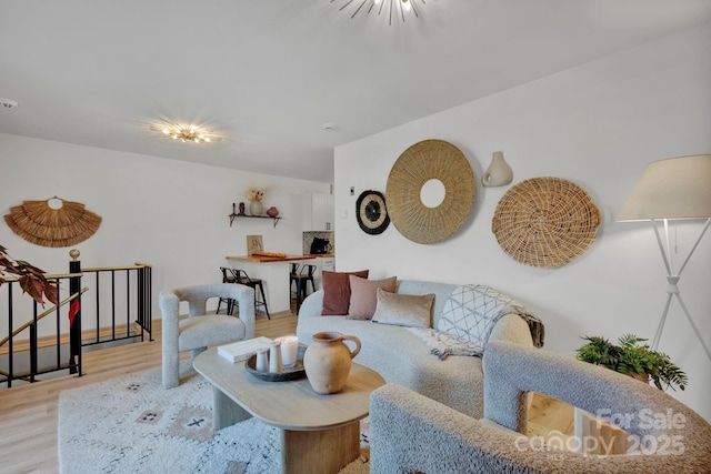 living room with light hardwood / wood-style flooring and a notable chandelier