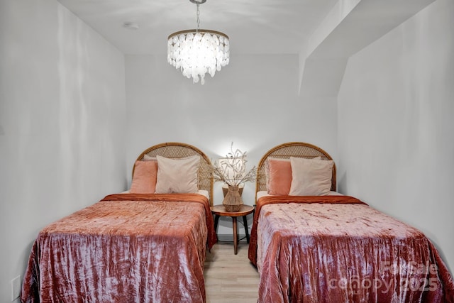 bedroom featuring a notable chandelier and light hardwood / wood-style floors