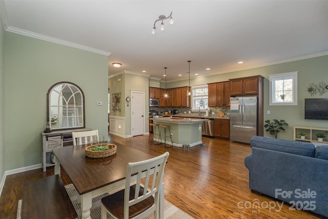 dining space featuring plenty of natural light, ornamental molding, and dark wood-type flooring