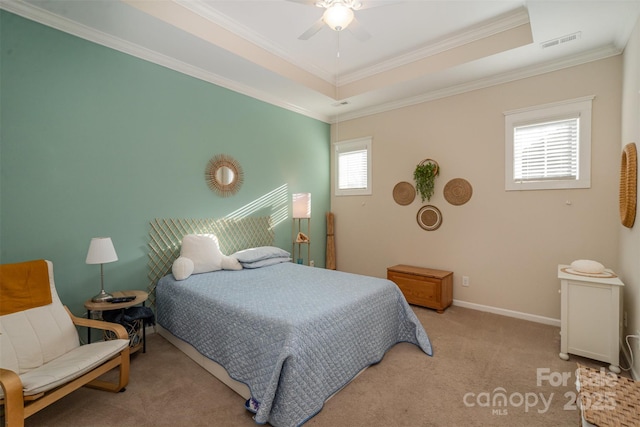 carpeted bedroom featuring a tray ceiling, ceiling fan, and crown molding