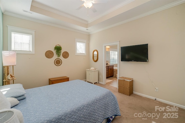 carpeted bedroom with connected bathroom, a tray ceiling, ceiling fan, and crown molding