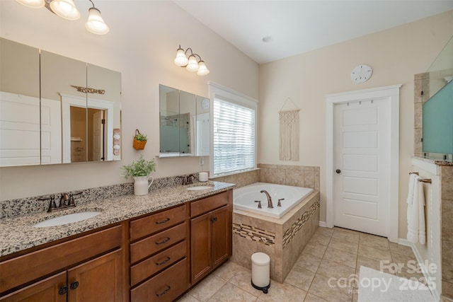 bathroom featuring tiled tub, tile patterned flooring, and vanity