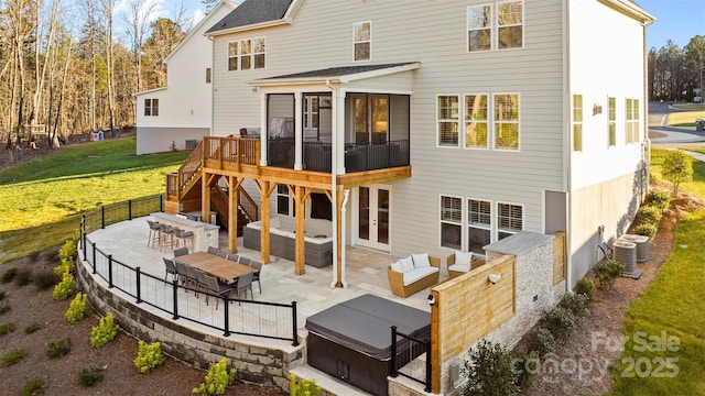 rear view of property featuring a patio, central AC, a deck, a lawn, and a jacuzzi