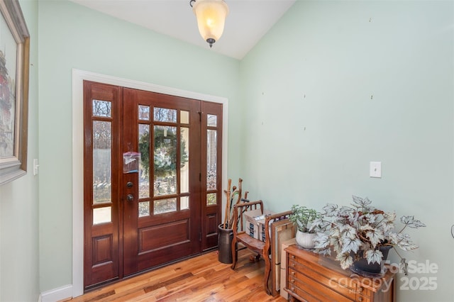 entrance foyer with lofted ceiling and light wood-type flooring