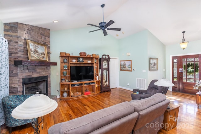 living room with a fireplace, hardwood / wood-style flooring, high vaulted ceiling, and ceiling fan