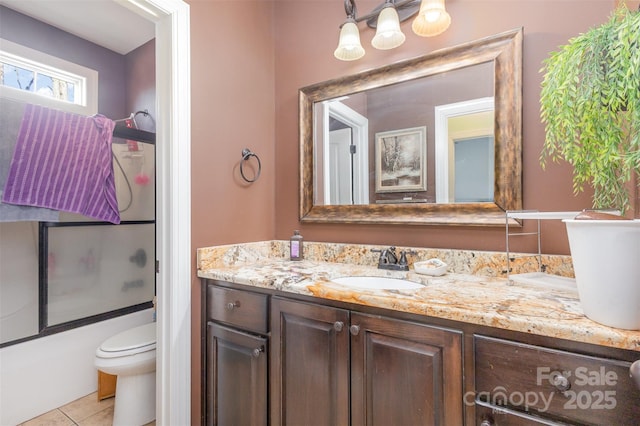 full bathroom featuring tile patterned flooring, vanity, toilet, and bath / shower combo with glass door