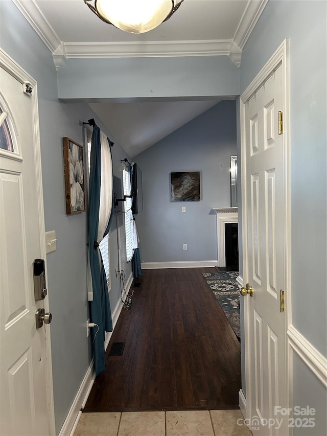 foyer featuring vaulted ceiling, tile patterned flooring, and crown molding