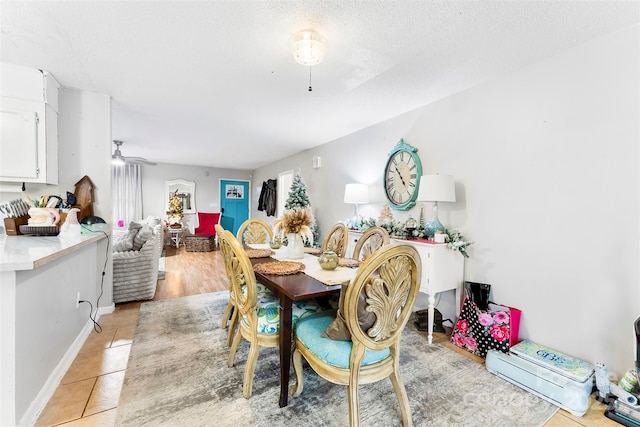 dining space featuring light tile patterned flooring and a textured ceiling