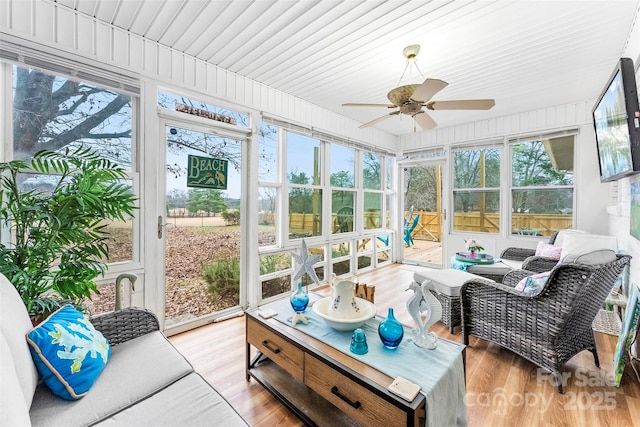 sunroom featuring ceiling fan and plenty of natural light