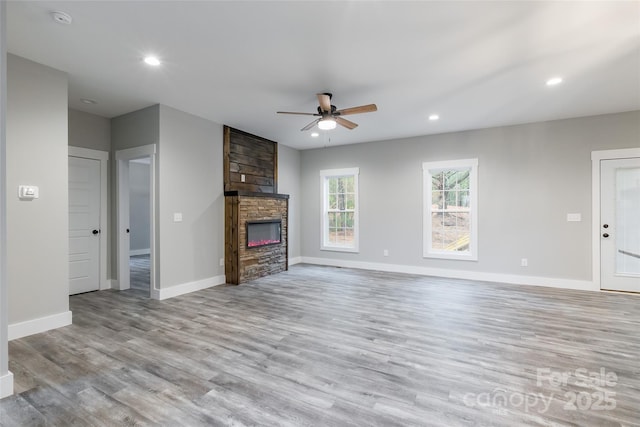 unfurnished living room with a fireplace, light hardwood / wood-style floors, and ceiling fan