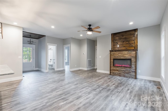 unfurnished living room featuring ceiling fan, a fireplace, and light hardwood / wood-style floors