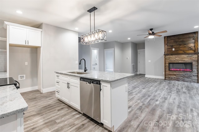 kitchen with stainless steel dishwasher, pendant lighting, white cabinetry, and sink