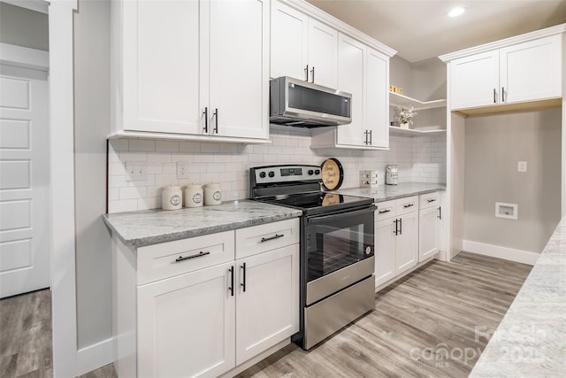 kitchen with light hardwood / wood-style floors, light stone countertops, white cabinetry, and stainless steel appliances