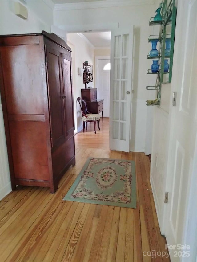 corridor featuring crown molding and light wood-style floors