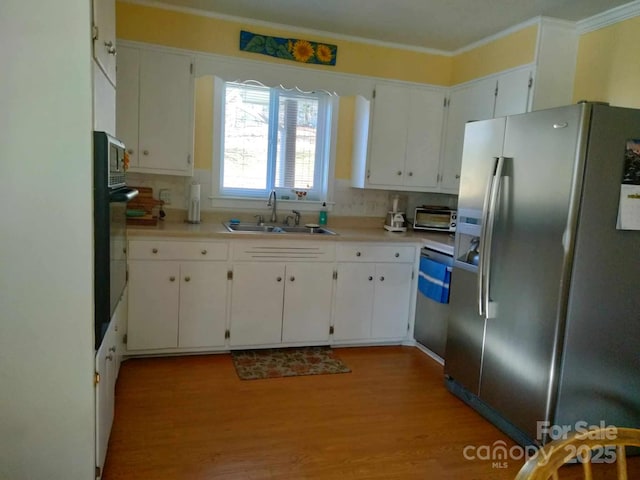 kitchen featuring white cabinets, stainless steel refrigerator with ice dispenser, a sink, and light countertops