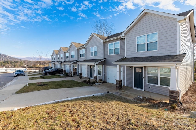 view of property with a garage and a front lawn