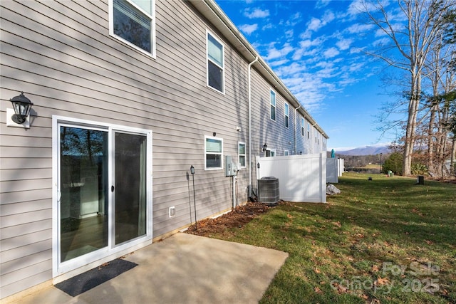 view of property exterior with a mountain view, a yard, a patio, and cooling unit