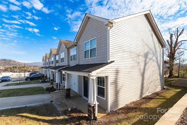 view of side of property with a mountain view and a patio area