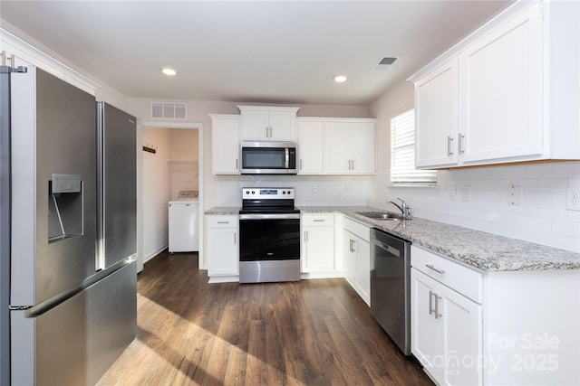 kitchen with light stone countertops, sink, stainless steel appliances, washer / clothes dryer, and white cabinets