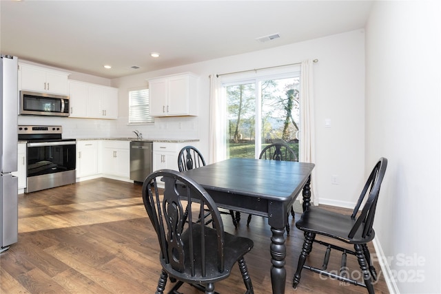 dining area with sink and dark wood-type flooring