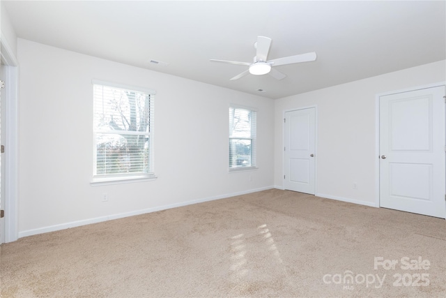 unfurnished bedroom with multiple windows, ceiling fan, and light colored carpet