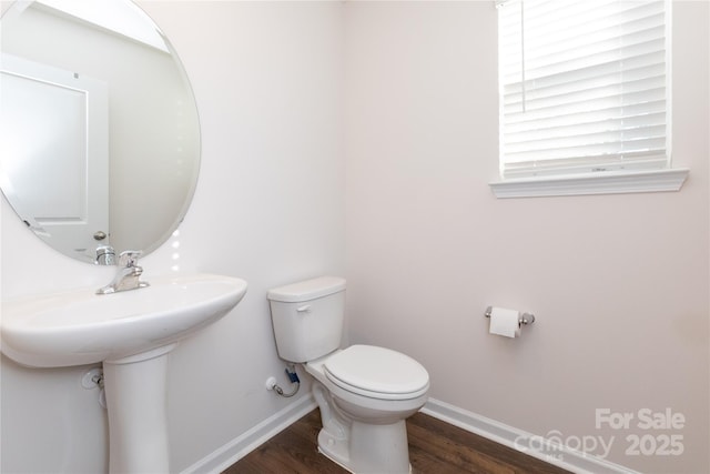 bathroom with toilet and hardwood / wood-style flooring