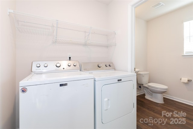 washroom with dark hardwood / wood-style flooring and washing machine and clothes dryer