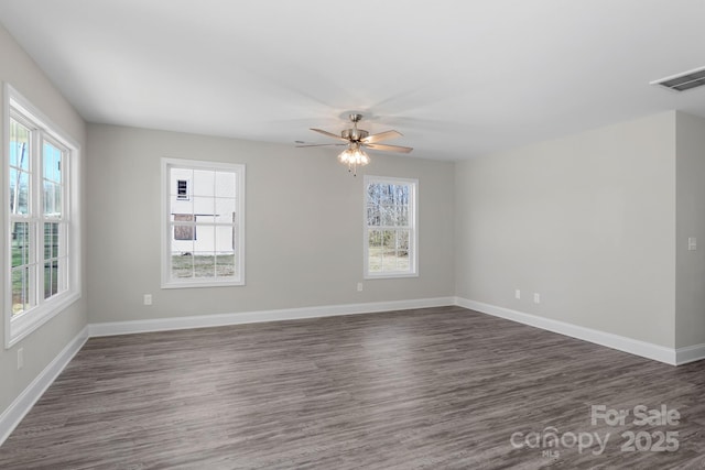 spare room featuring plenty of natural light, dark wood-type flooring, and ceiling fan