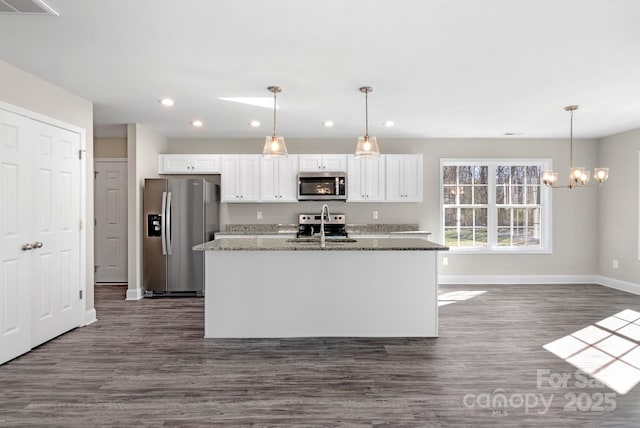 kitchen featuring sink, white cabinetry, stone countertops, an island with sink, and stainless steel appliances