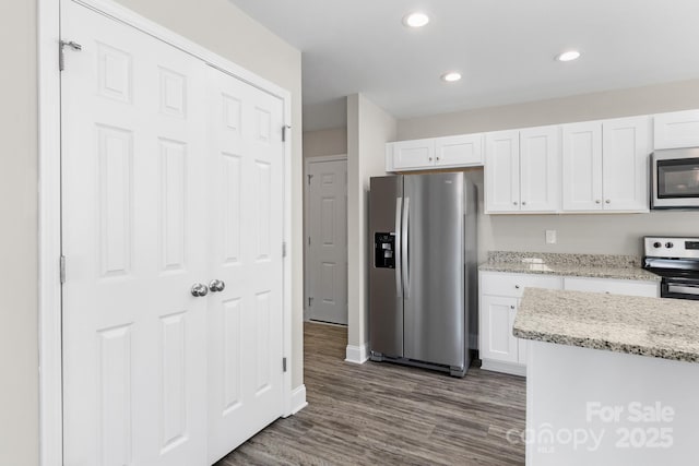 kitchen featuring light stone counters, dark hardwood / wood-style floors, white cabinets, and appliances with stainless steel finishes