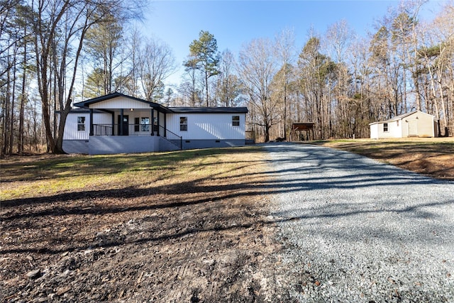 exterior space featuring a lawn, a porch, and a storage shed