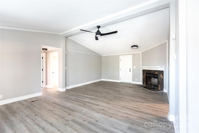 unfurnished living room with a premium fireplace, ceiling fan, vaulted ceiling, and light wood-type flooring