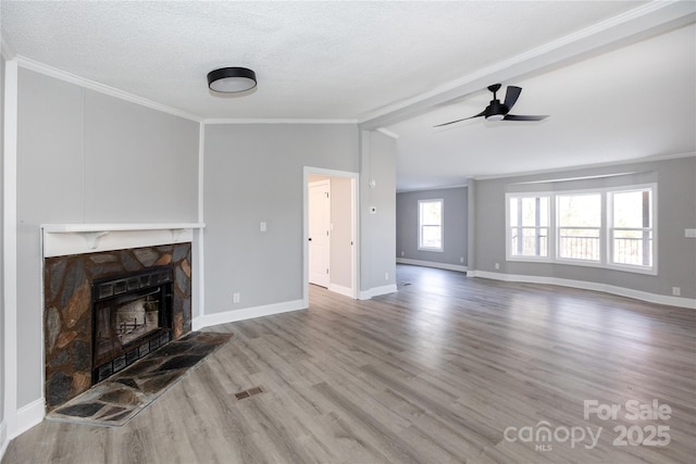 unfurnished living room featuring crown molding, lofted ceiling, a textured ceiling, a fireplace, and hardwood / wood-style flooring