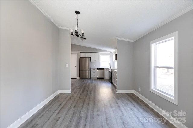 unfurnished living room with light wood-type flooring, crown molding, sink, an inviting chandelier, and lofted ceiling