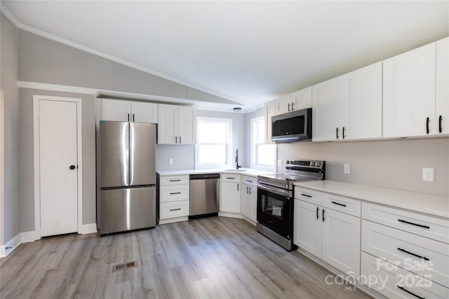 kitchen featuring white cabinetry, vaulted ceiling, and appliances with stainless steel finishes