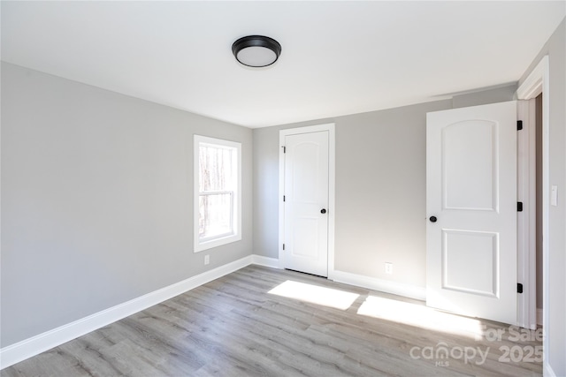 unfurnished bedroom with light hardwood / wood-style flooring and a closet