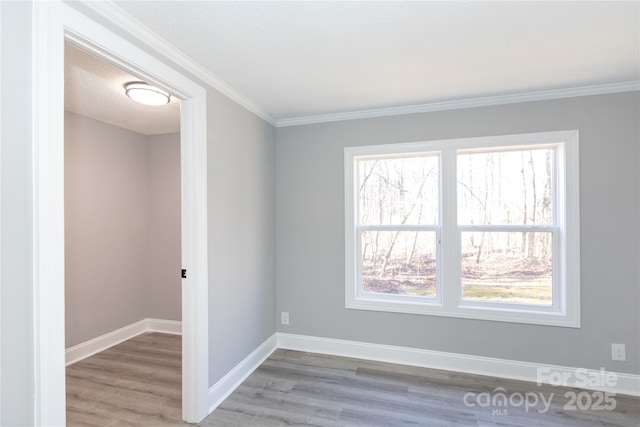 unfurnished room with a textured ceiling, hardwood / wood-style flooring, and ornamental molding