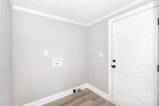 washroom with washer hookup, light wood-type flooring, a textured ceiling, and ornamental molding