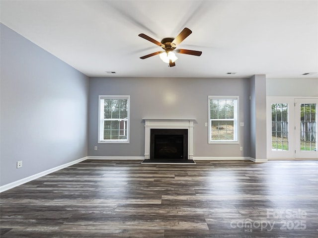 unfurnished living room featuring ceiling fan and dark hardwood / wood-style flooring