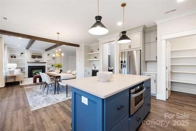 kitchen with tasteful backsplash, stainless steel appliances, beam ceiling, a kitchen island, and hanging light fixtures