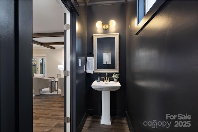 bathroom featuring beamed ceiling, hardwood / wood-style flooring, and sink