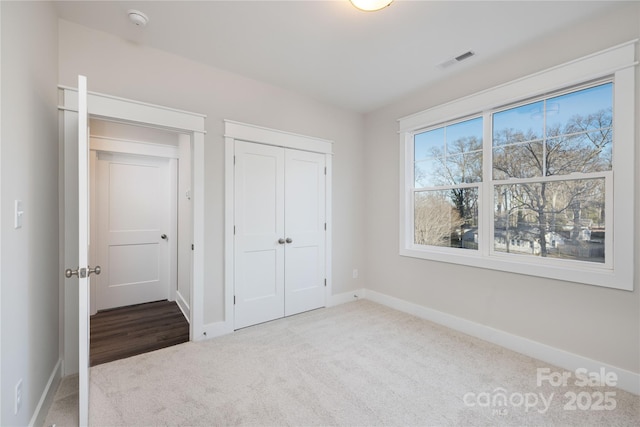 unfurnished bedroom featuring carpet flooring and a closet